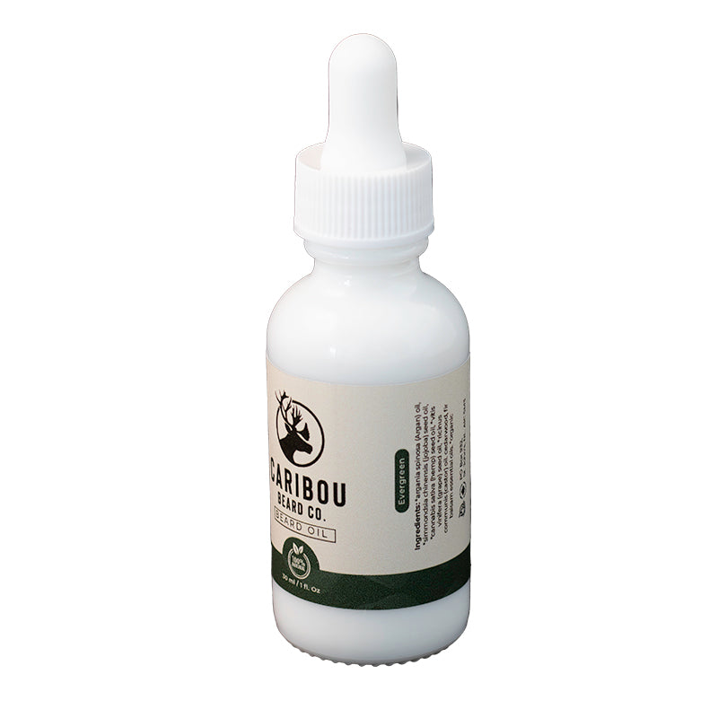 a 1oz/30ml white dropper bottle of Caribou Beard Co's Beard Oil in Evergreen scent, side view.