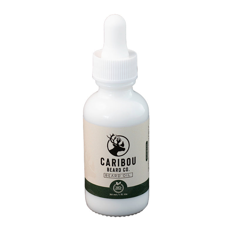 a 1oz/30ml white dropper bottle of Caribou Beard Co's Beard Oil in Evergreen scent, front on view.